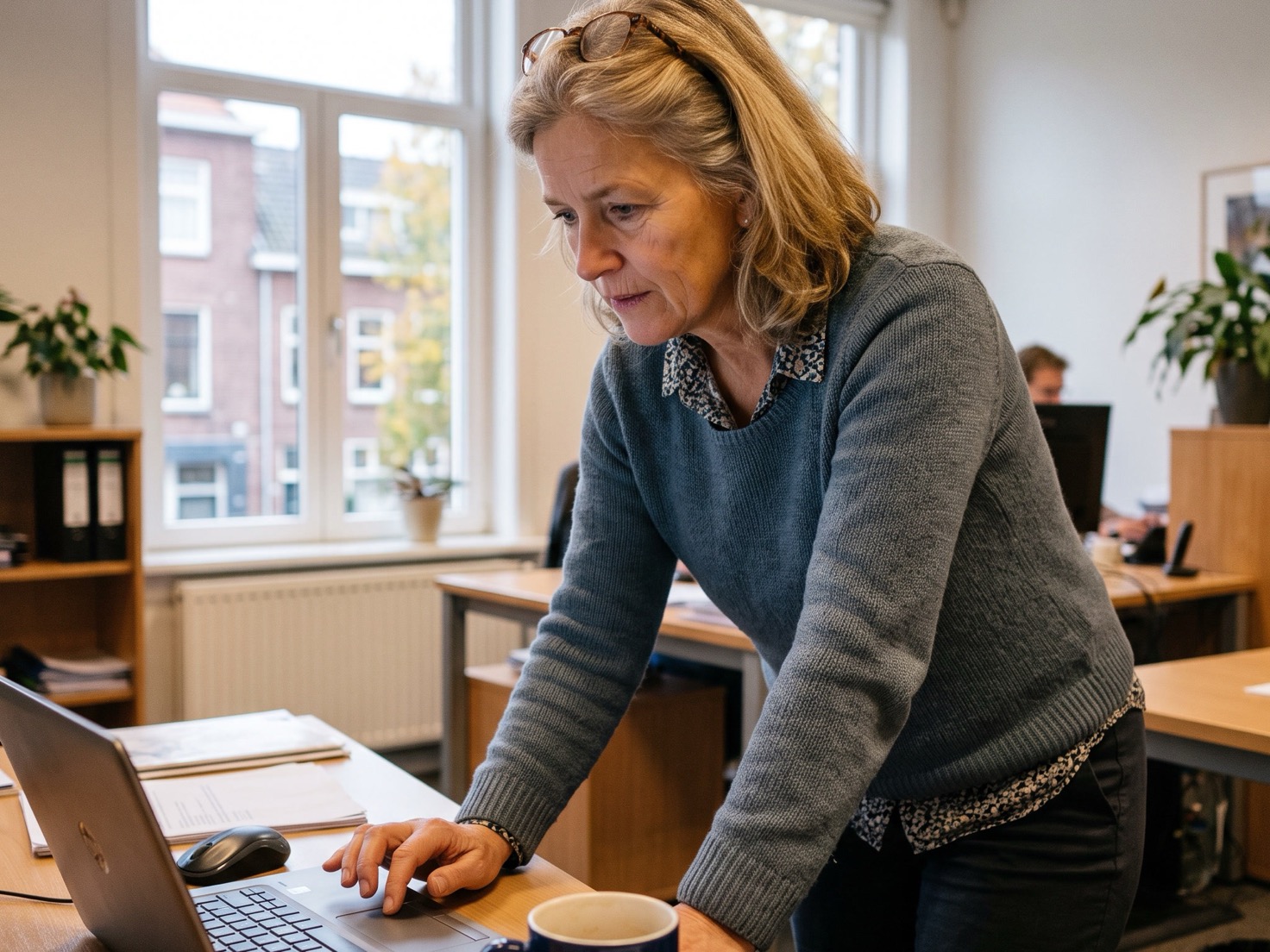 Adviseur past iets aan op haar laptop in een rustig advieskantoor