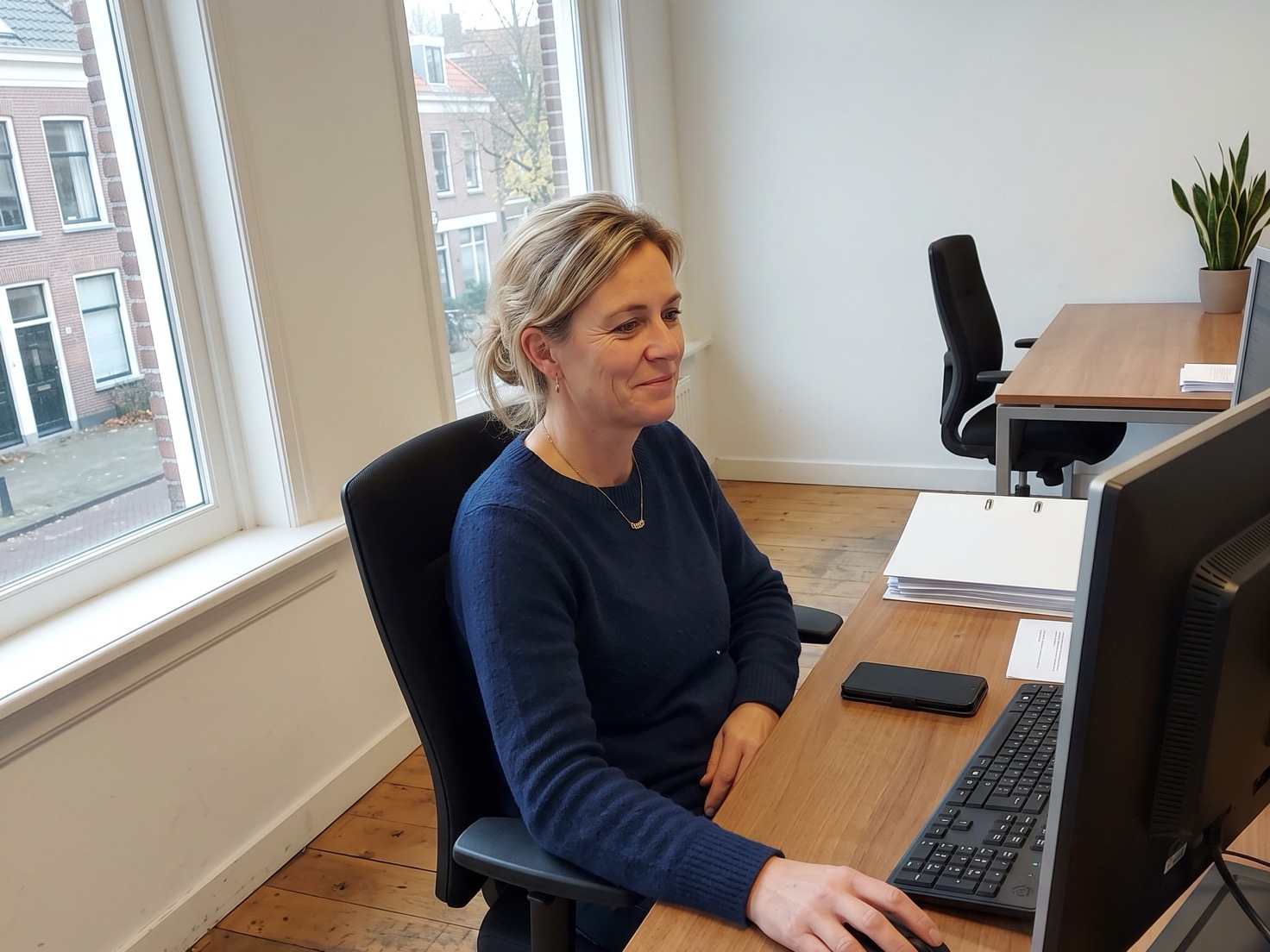 Financieel adviseur werkt achter haar bureau in een rustig, leeg advieskantoor
