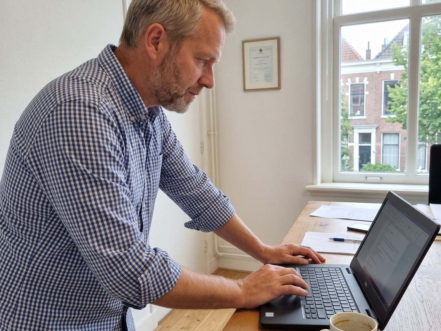 Financieel adviseur bekijkt aandachtig een rapport op zijn laptop op kantoor