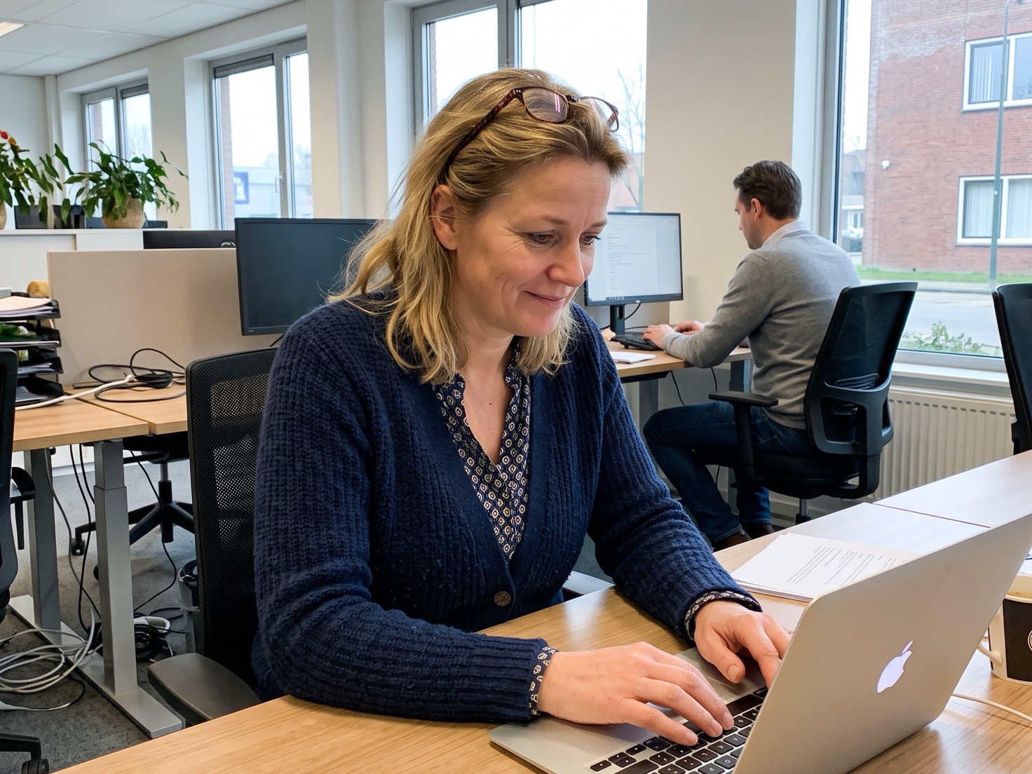 Adviseur werkt geconcentreerd achter haar laptop op kantoor