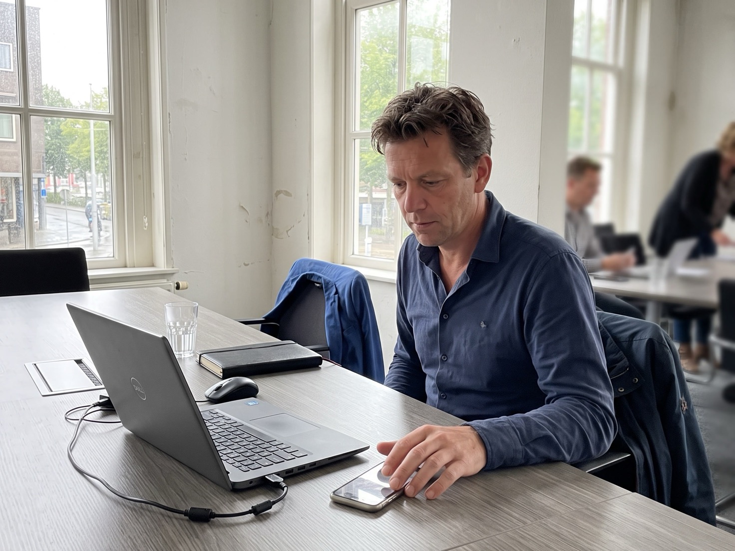 Financieel adviseur aan een overlegtafel belt een klant na van wie het mailadres niet meer werkt