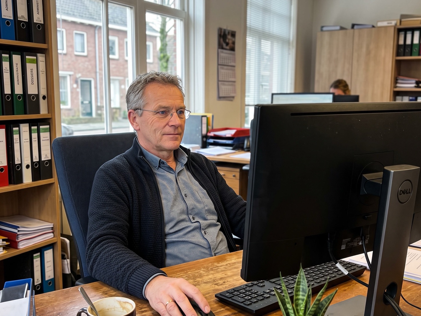 Adviseur werkt achter zijn bureau in een rustig Nederlands kantoor