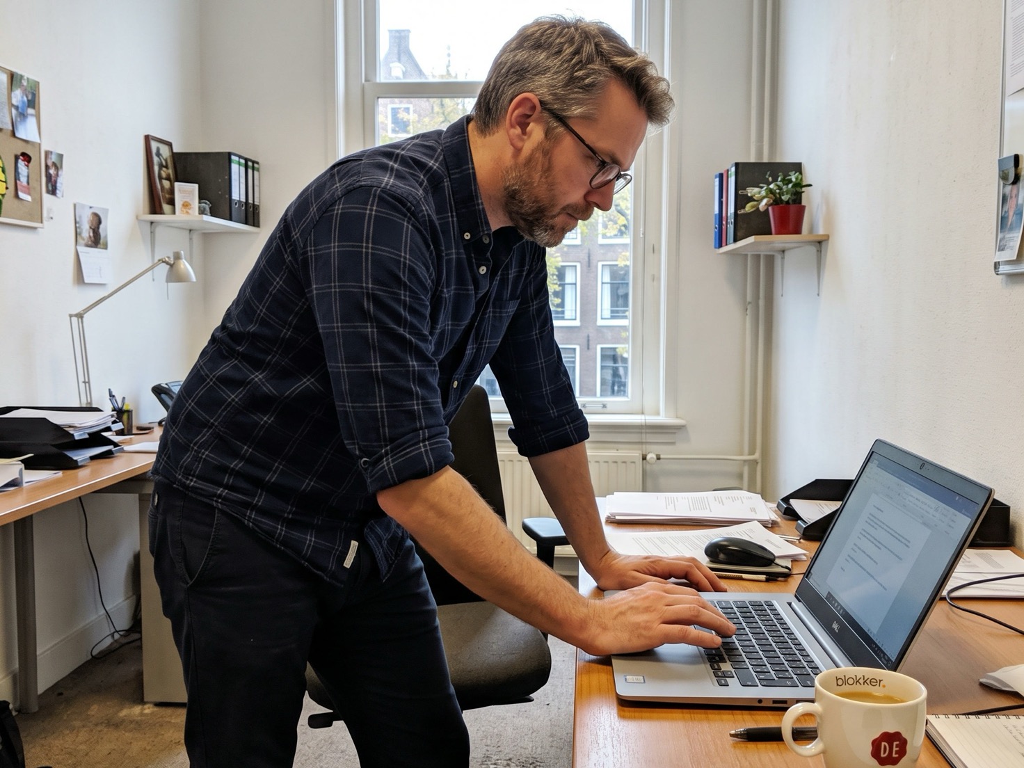 Adviseur bekijkt domeinnamen van zijn kantoor op een laptop in een rustig kantoor