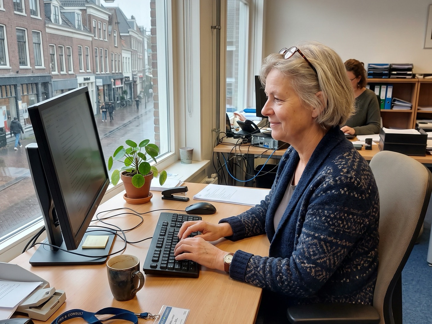 Adviseur werkt achter haar bureau nadat ze een dubbele Google-vermelding heeft rechtgezet
