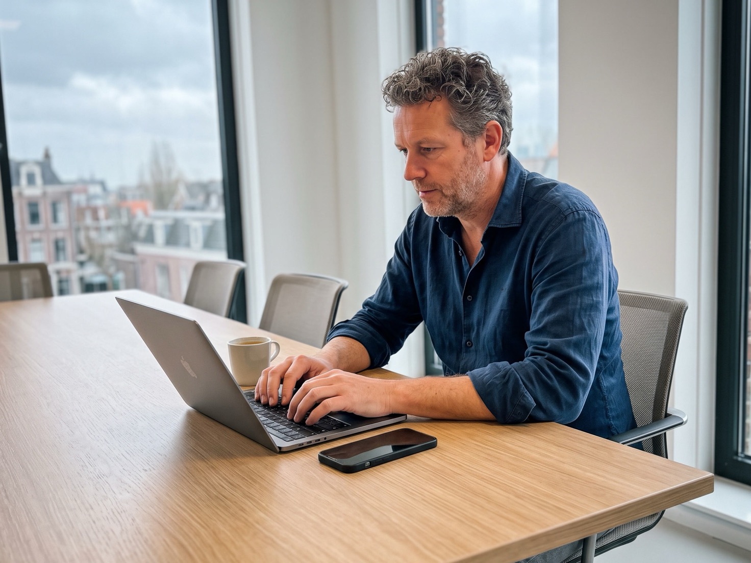 Financieel adviseur zet aan de overlegtafel een advertentie klaar op zijn laptop