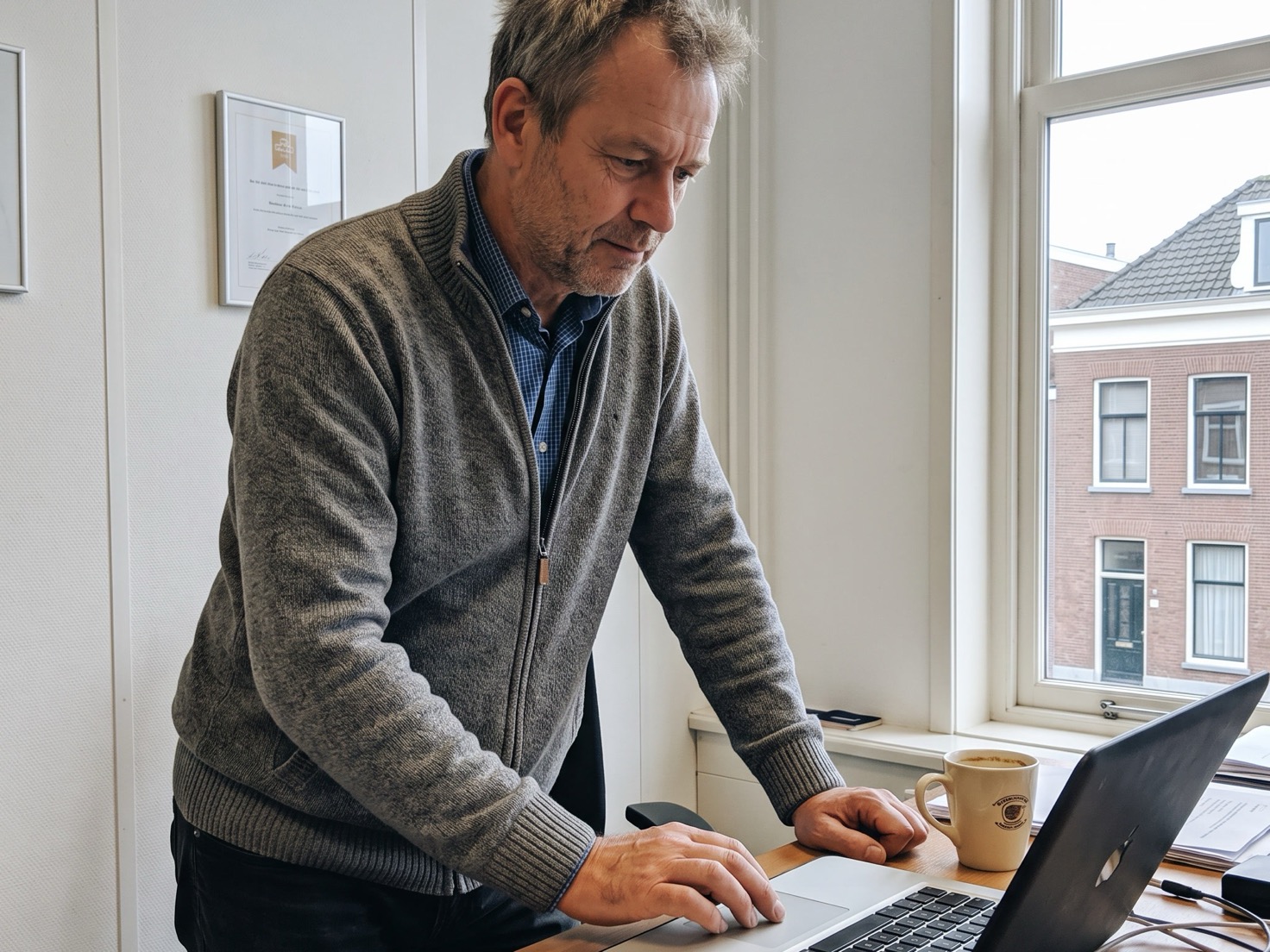 Financieel adviseur controleert iets op zijn laptop aan zijn bureau