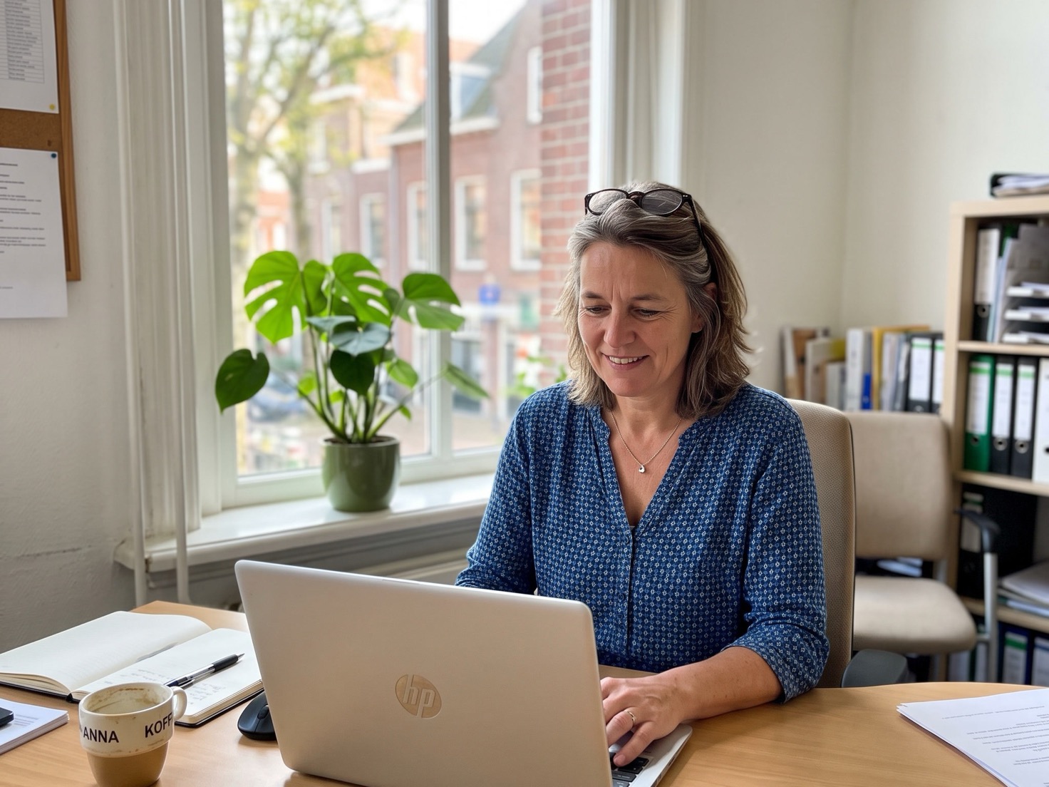 Financieel adviseur achter haar bureau in een rustig advieskantoor, scherm van de camera af