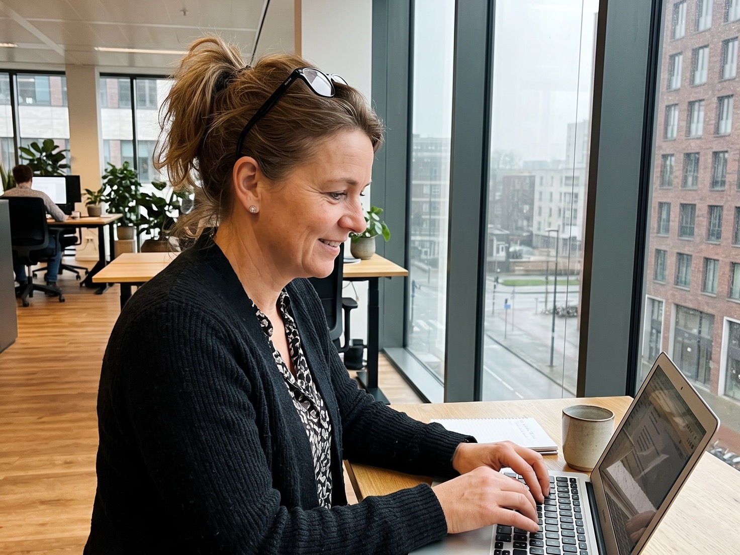 Adviseur werkt bij het raam aan het stappenplan voor haar website