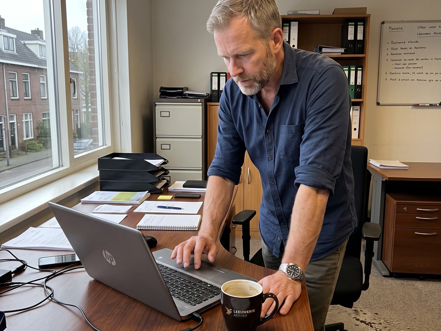 Financieel adviseur werkt naast zijn bureau aan de laptop op kantoor