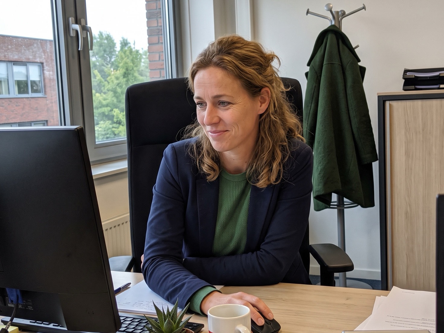 Financieel adviseur werkt geconcentreerd achter haar bureau in een rustig advieskantoor