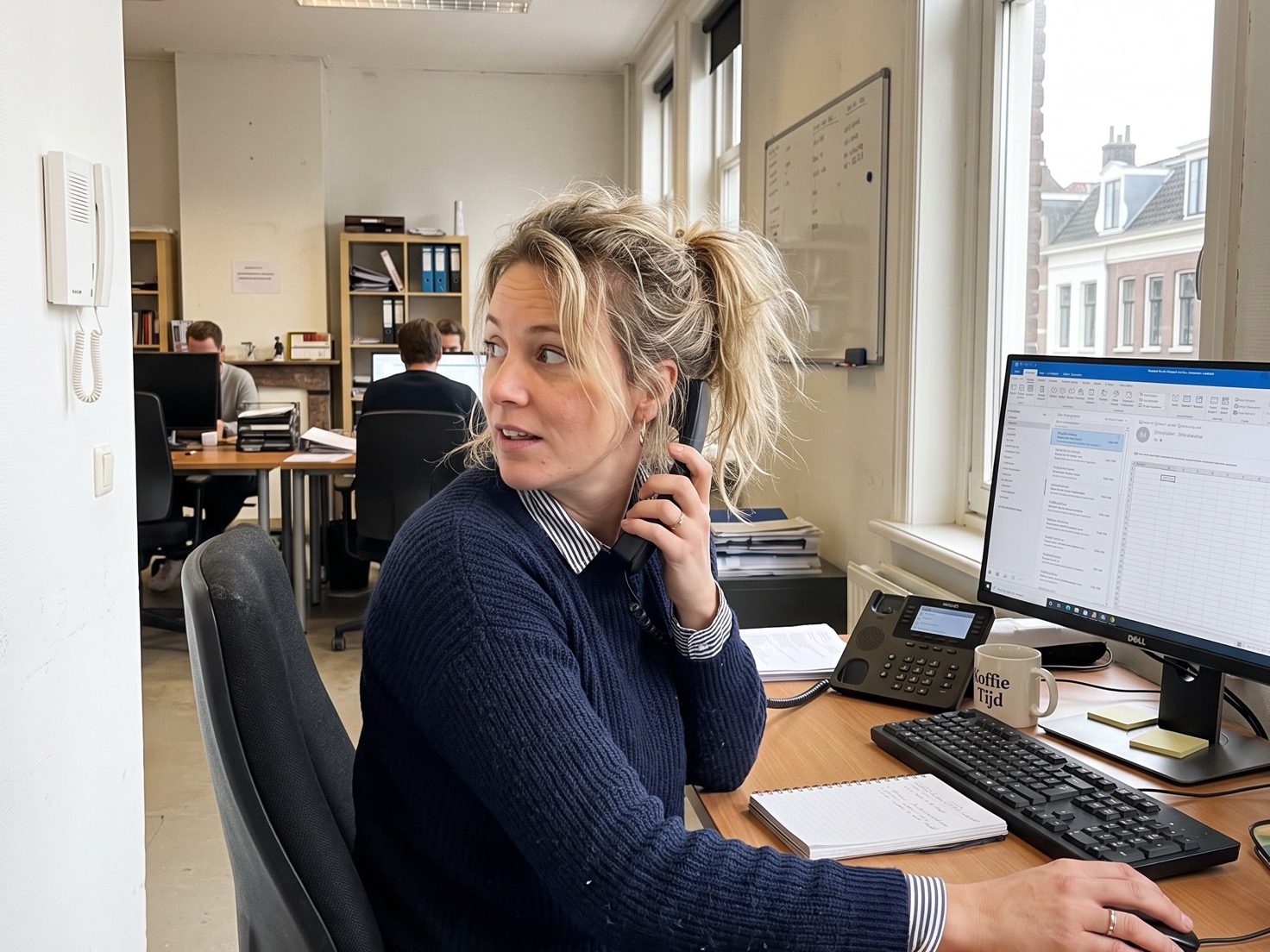 Financieel adviseur achter haar bureau in een advieskantoor, bezig met het inplannen van een kennismakingsgesprek.
