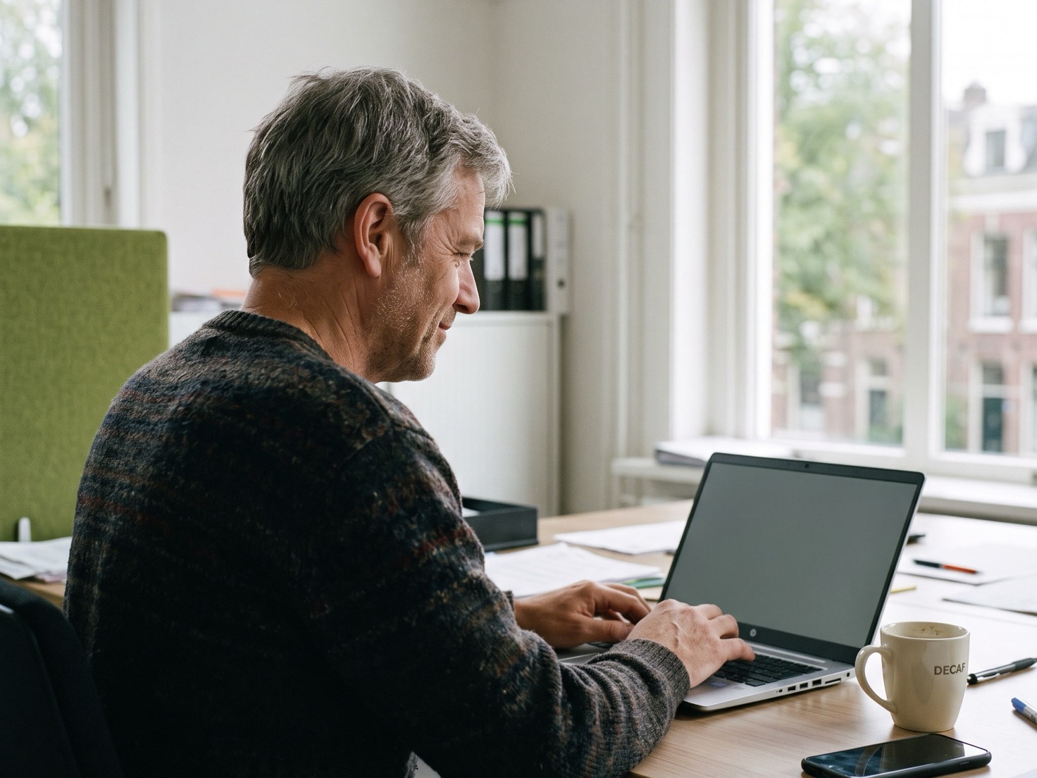 Financieel adviseur werkt geconcentreerd achter zijn laptop in een rustig kantoor
