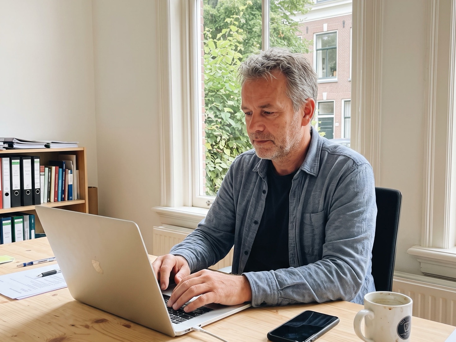 Financieel adviseur werkt geconcentreerd achter zijn bureau in een rustig kantoor