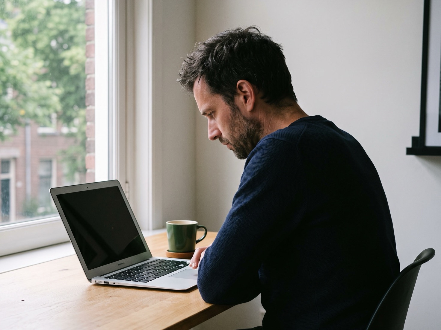 Adviseur werkt geconcentreerd achter zijn laptop aan een opgeruimd bureau