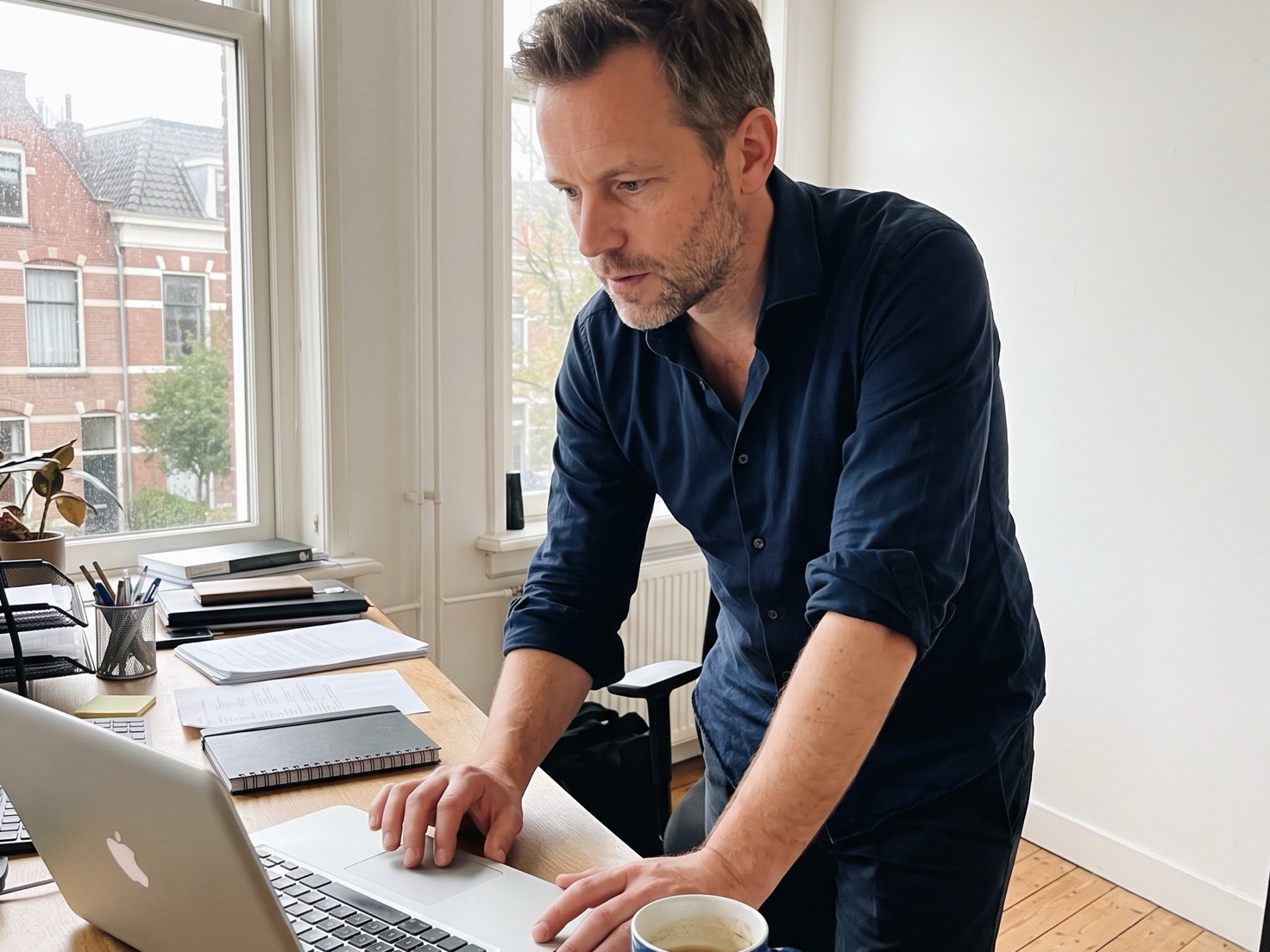 Adviseur werkt geconcentreerd aan zijn laptop op kantoor, met het scherm van de camera afgewend
