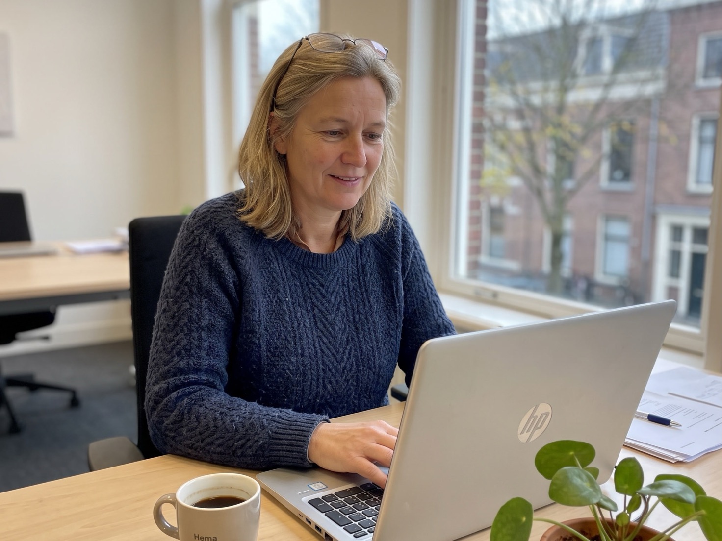 Financieel adviseur werkt geconcentreerd achter een laptop in een rustig advieskantoor