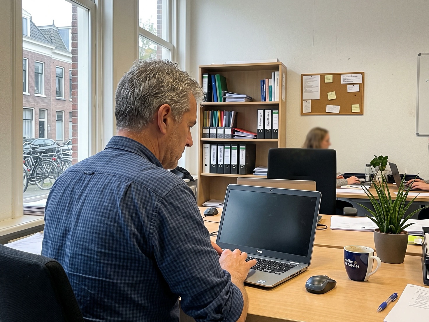 Financieel adviseur werkt achter zijn bureau op een laptop in een rustig advieskantoor
