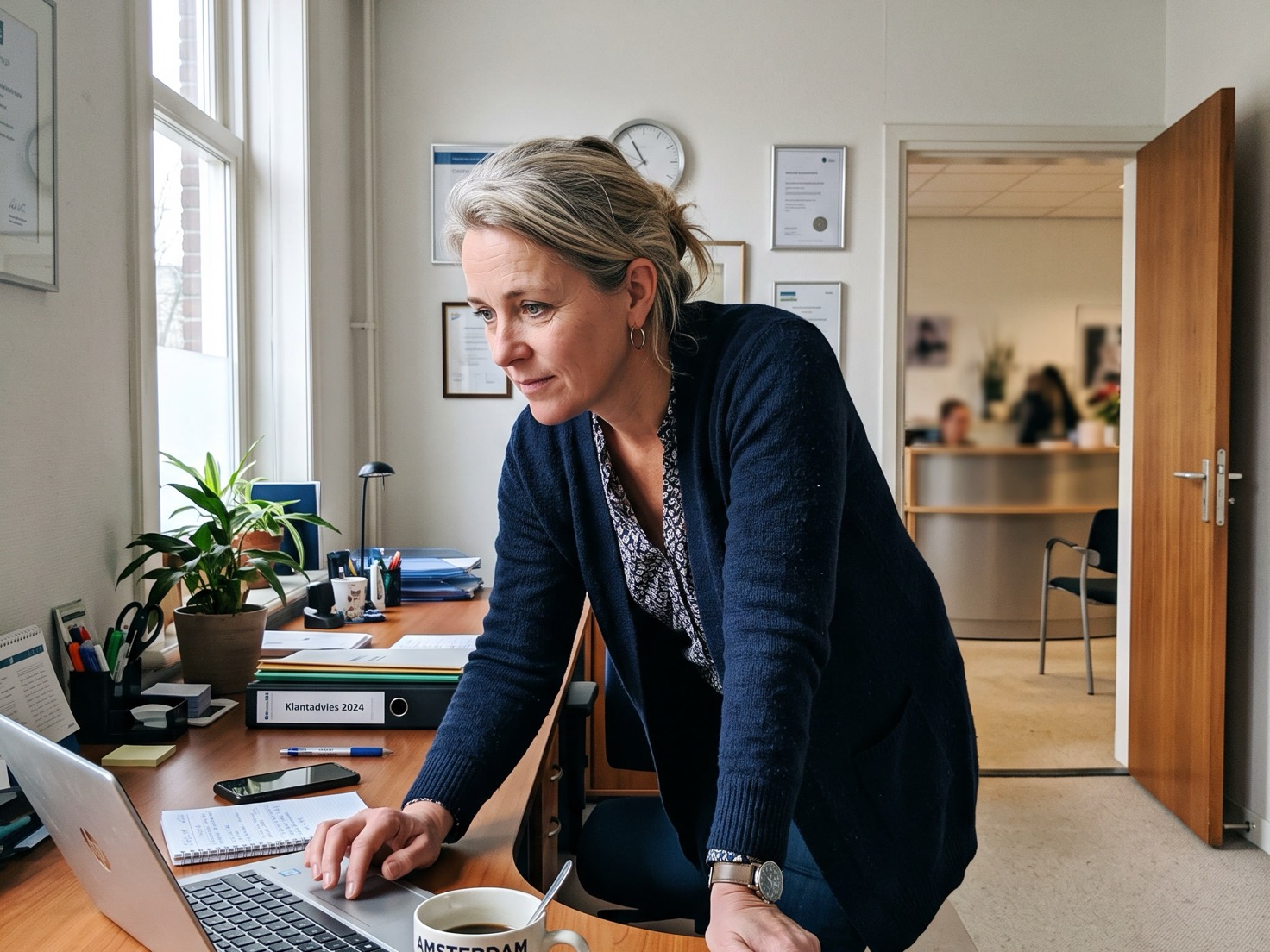 Financieel adviseur aan haar bureau, de deur naar de ontvangstruimte staat open