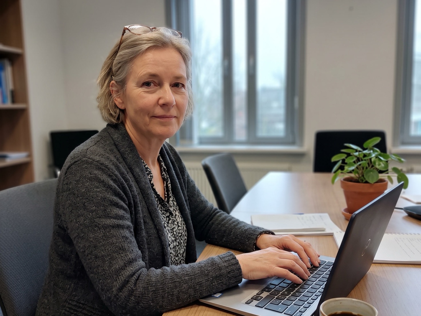Financieel adviseur bekijkt een rekentool op een laptop aan de overlegtafel van haar kantoor