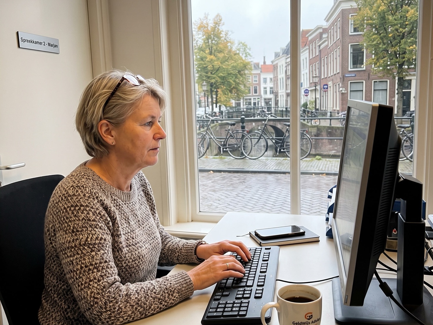 Financieel adviseur werkt geconcentreerd aan haar bureau in een rustig advieskantoor