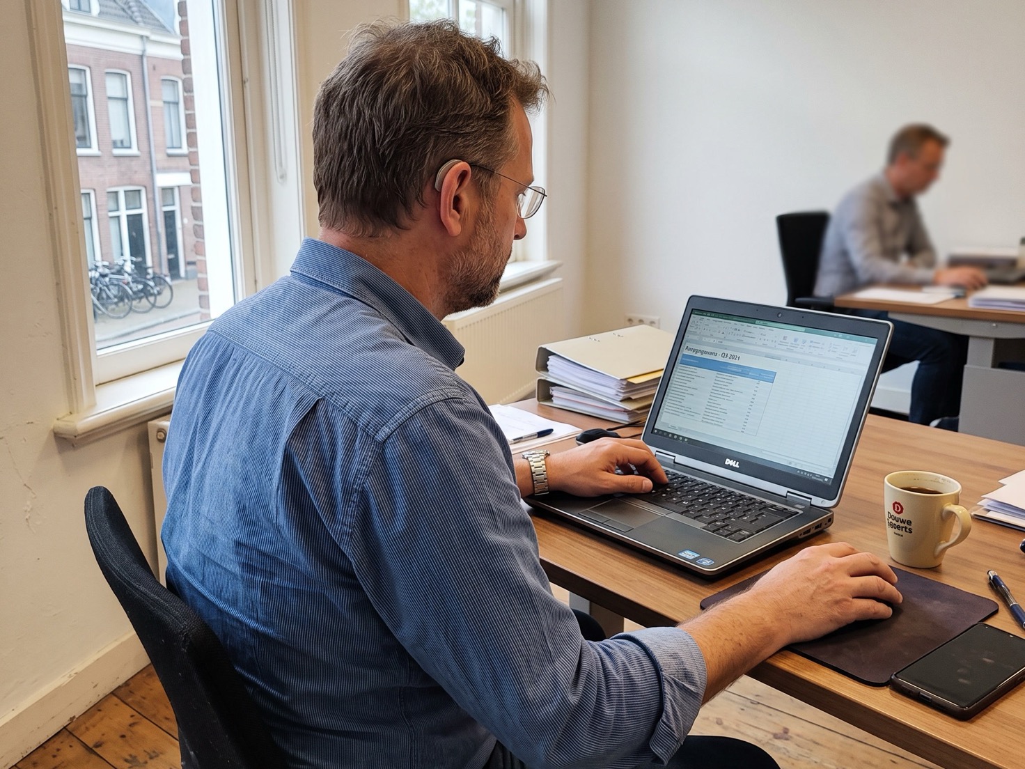 Adviseur werkt aan een nieuw klantdossier achter zijn laptop