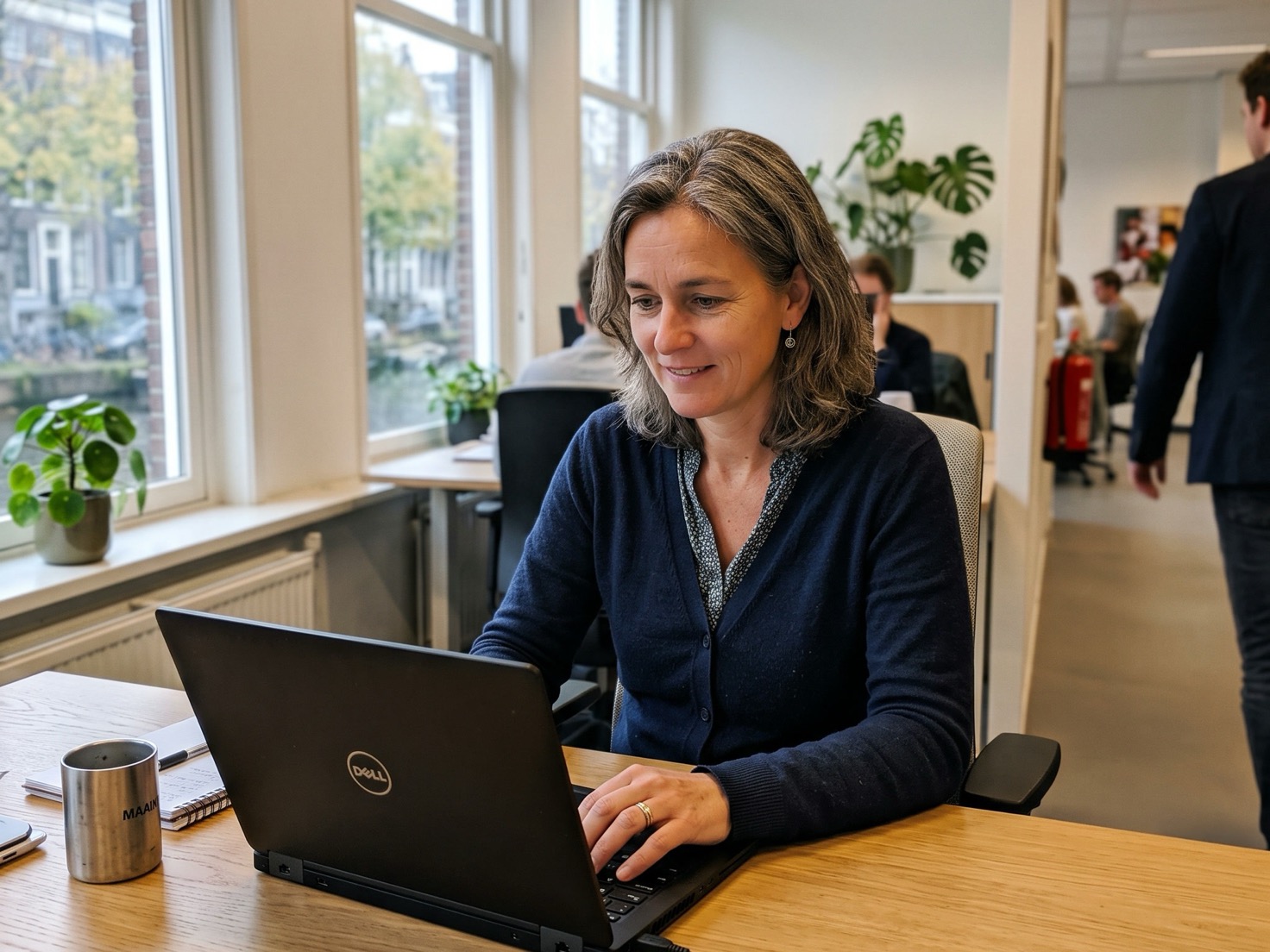 Financieel adviseur die geconcentreerd achter haar laptop werkt in een rustig advieskantoor