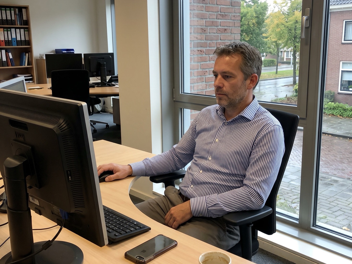 Financieel adviseur werkt achter zijn bureau in een rustig advieskantoor