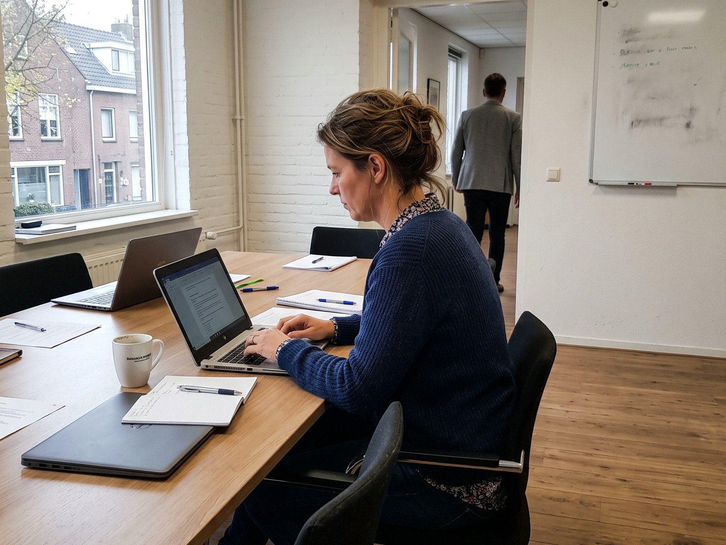Financieel adviseur werkt aan een laptop aan de overlegtafel van een advieskantoor