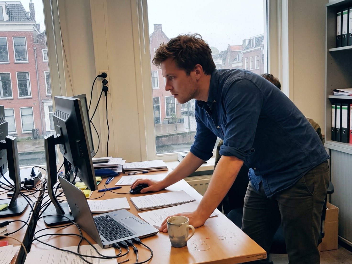 Financieel adviseur bekijkt staand de zoekstatistieken van zijn website op een beeldscherm