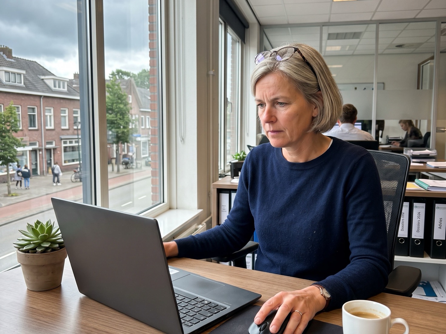 Financieel adviseur bekijkt zoekwoordgegevens achter haar laptop op kantoor