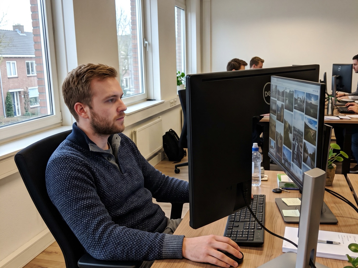 Financieel adviseur bekijkt de beelden op de website van zijn kantoor achter zijn bureau